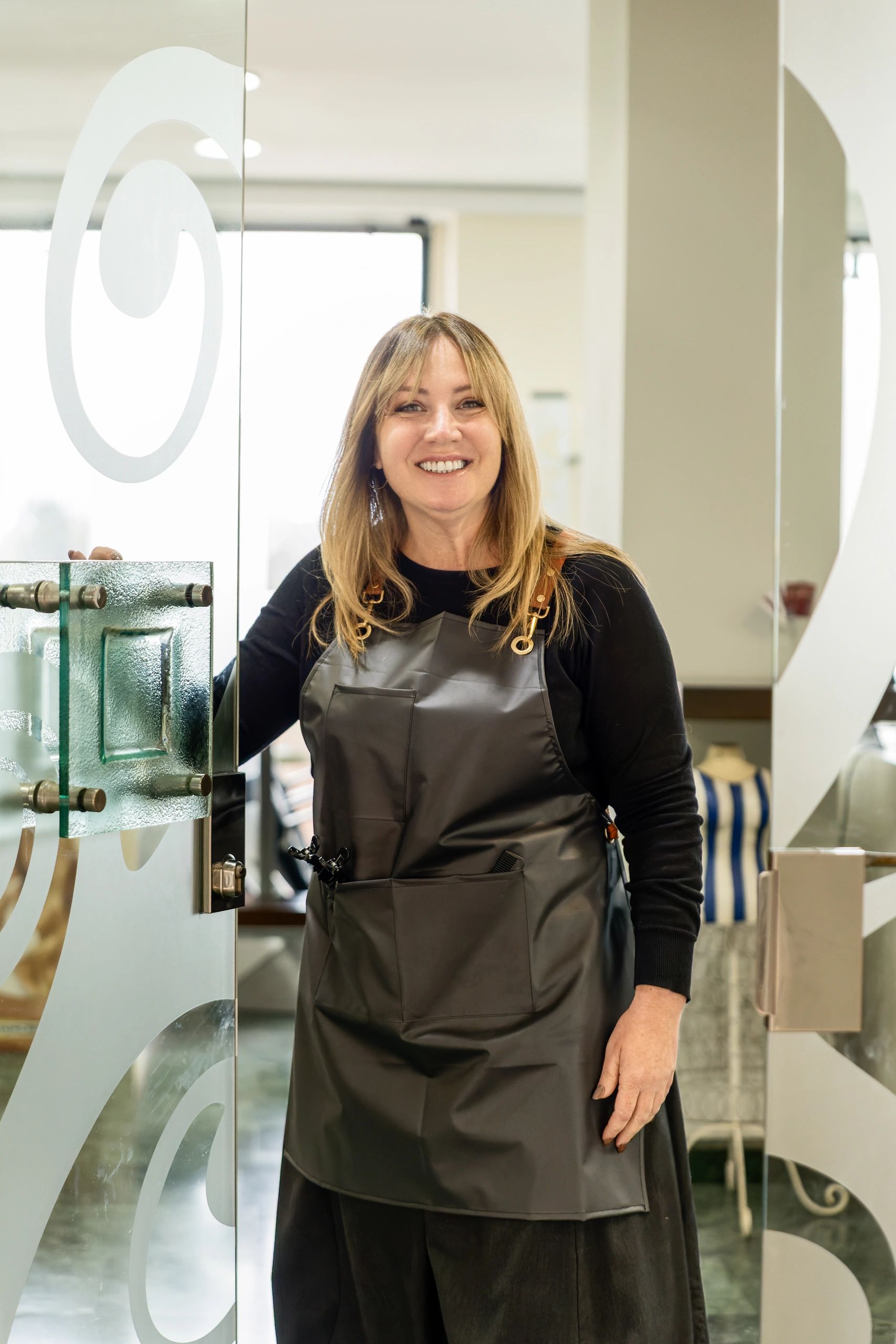 Professional hairstylist welcoming clients at a modern salon